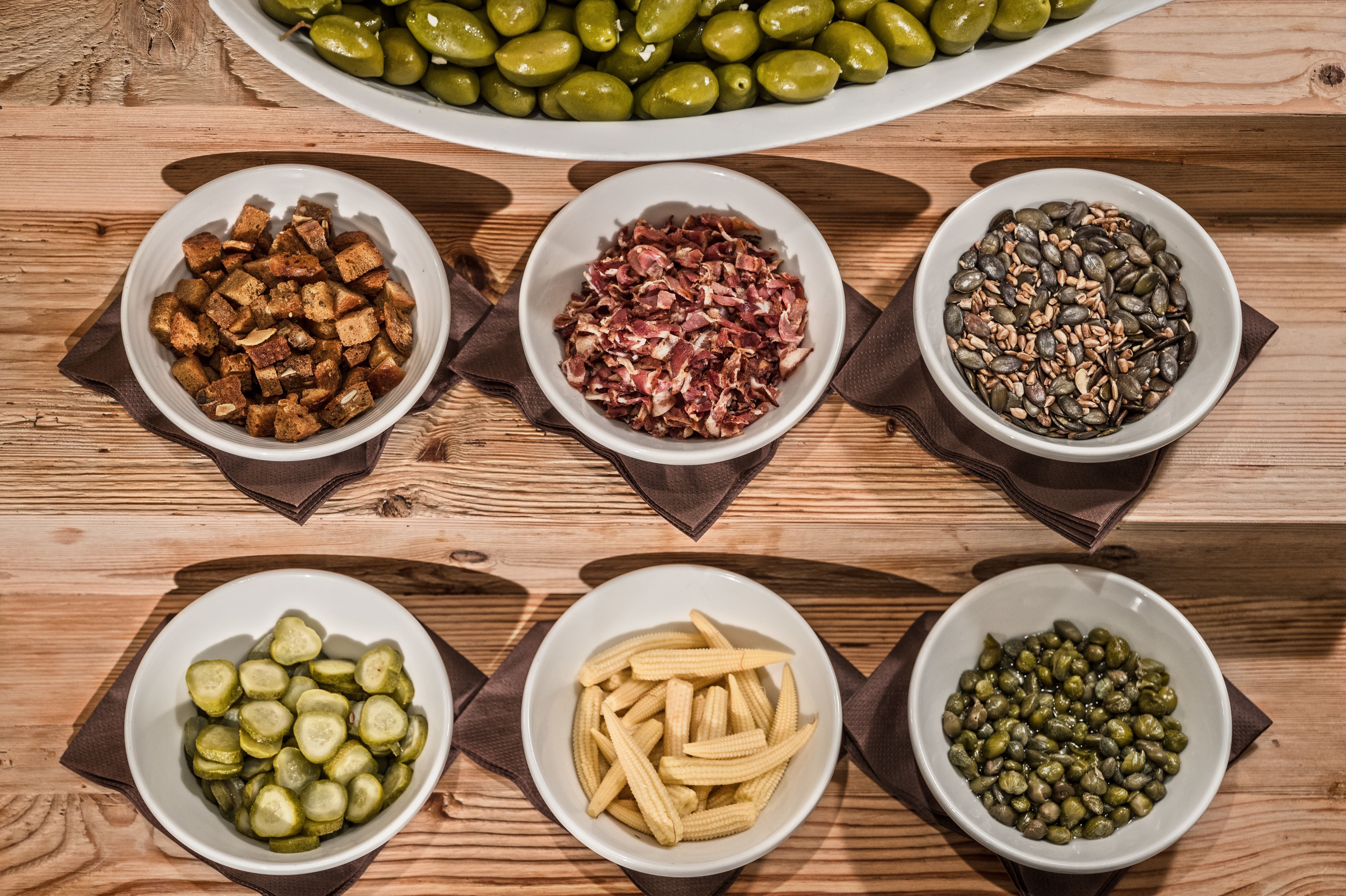Taula de fusta amb sis bols que contenen diversos aliments.