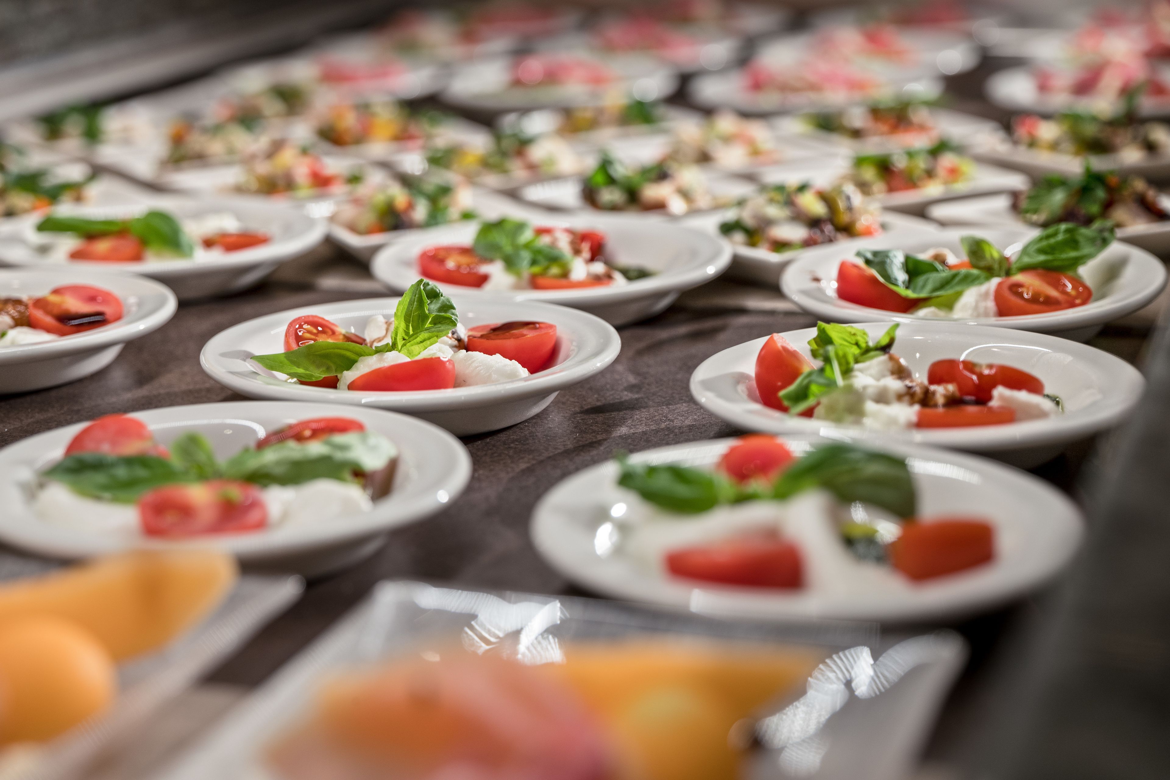 A buffet with various dishes, including salads and appetizers, arranged on plates.