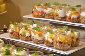 A buffet with various food items arranged on trays.