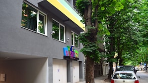 A building with a sign that reads "VISITO" and a parked car. - Visito Apart House (Sofia)
