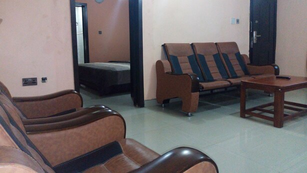 A room with a sofa set, a small table, and a bed. - Akma Signature Hotel & Suites (Ibadan)