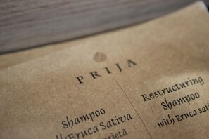 A close-up of a menu with the word "PRIJJA" and a list of items including "Restructuring Shampoo with Eruca Sativa." - Albergo Ristorante Bismantova (Castelnovo ne' Monti)
