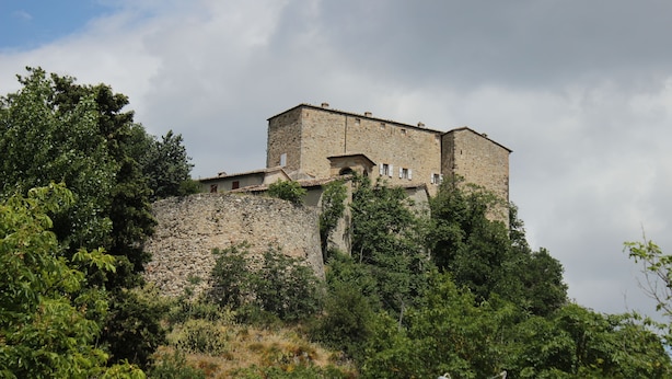 A historic stone building with multiple levels, surrounded by lush greenery. - Albergo Ristorante Bismantova (Castelnovo ne' Monti)