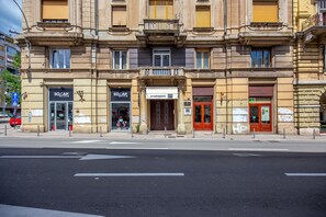 A building with multiple storefronts, including 'SO CAP' and 'APARTMENTS ONE'.