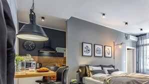 A modern bedroom with a bed, bedside tables, a desk with a chair, a clock, and framed pictures on the wall. - Number 1 Apartments Rijeka (Rijeka)