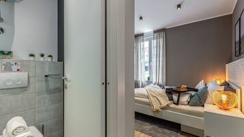A modern bathroom with a toilet, hand towel dispenser, and a shower area.