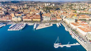 An aerial view of a coastal city with a marina, buildings, and a hilly landscape in the background. - Number 1 Deluxe Apartments (Rijeka)
