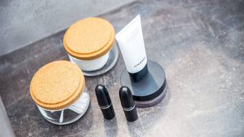 Una exhibición de productos cosméticos que incluye un tubo con la etiqueta "CHANEL" y dos recipientes cilíndricos.