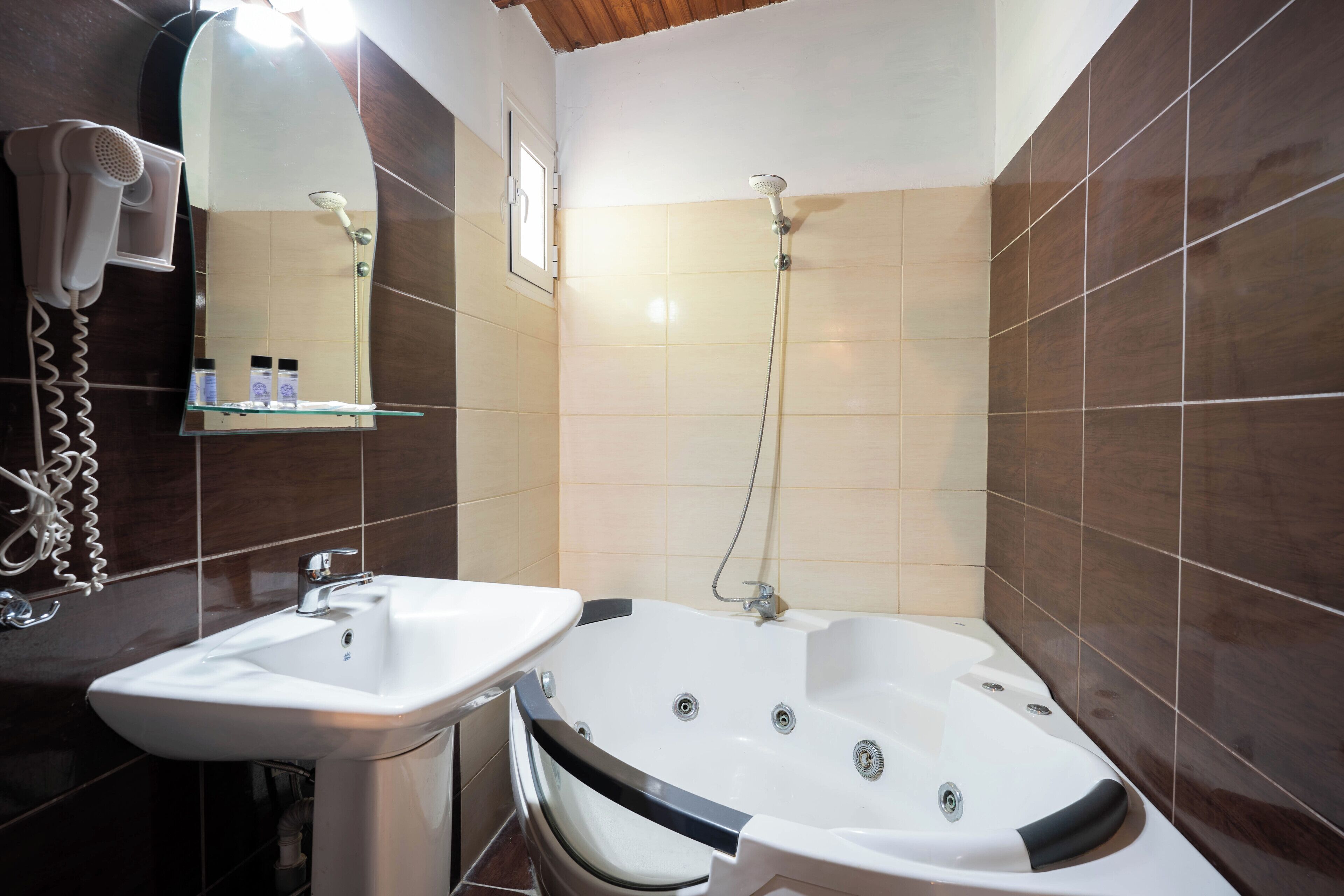 A bathroom with a white sink, a large bathtub, and a showerhead.