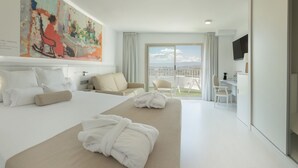 A hotel room with a large bed, a sofa, a balcony with a view, and a flat-screen TV. - Villa Luz Family Gourmet (Gandia)
