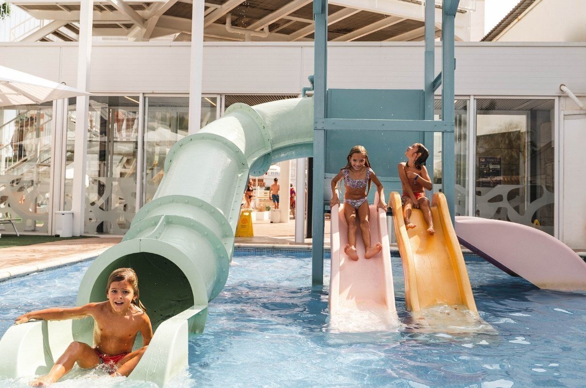 Un área de piscina con toboganes y una piscina.