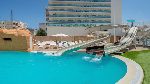 A pool with a water slide, lounge chairs, and a building in the background. - Villa Luz Family Gourmet (Gandia)