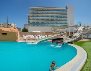 A pool with a water slide, lounge chairs, and a building in the background. - Villa Luz Family Gourmet (Gandia)