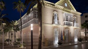 Un edificio histórico con fachada clásica, ventanas amplias y un reloj destacado.