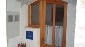 Uma porta de madeira com painel de vidro e uma placa indicando um apartamento tipo studio.