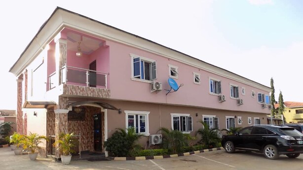 A two-story building with a balcony on the upper floor, air conditioning units, and a satellite dish. - De Fellas Palace Hotel & Suites (Ibadan)