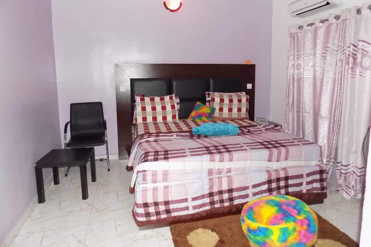 Ein Schlafzimmer mit einem Bett, einem Sessel, einem Teppich und einem bunten Ball.