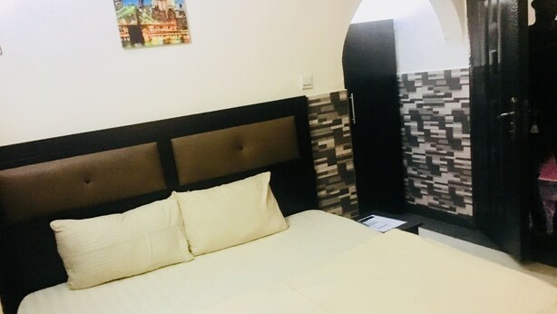 Uma cama com cabeceira, um travesseiro e uma parede com padrão.