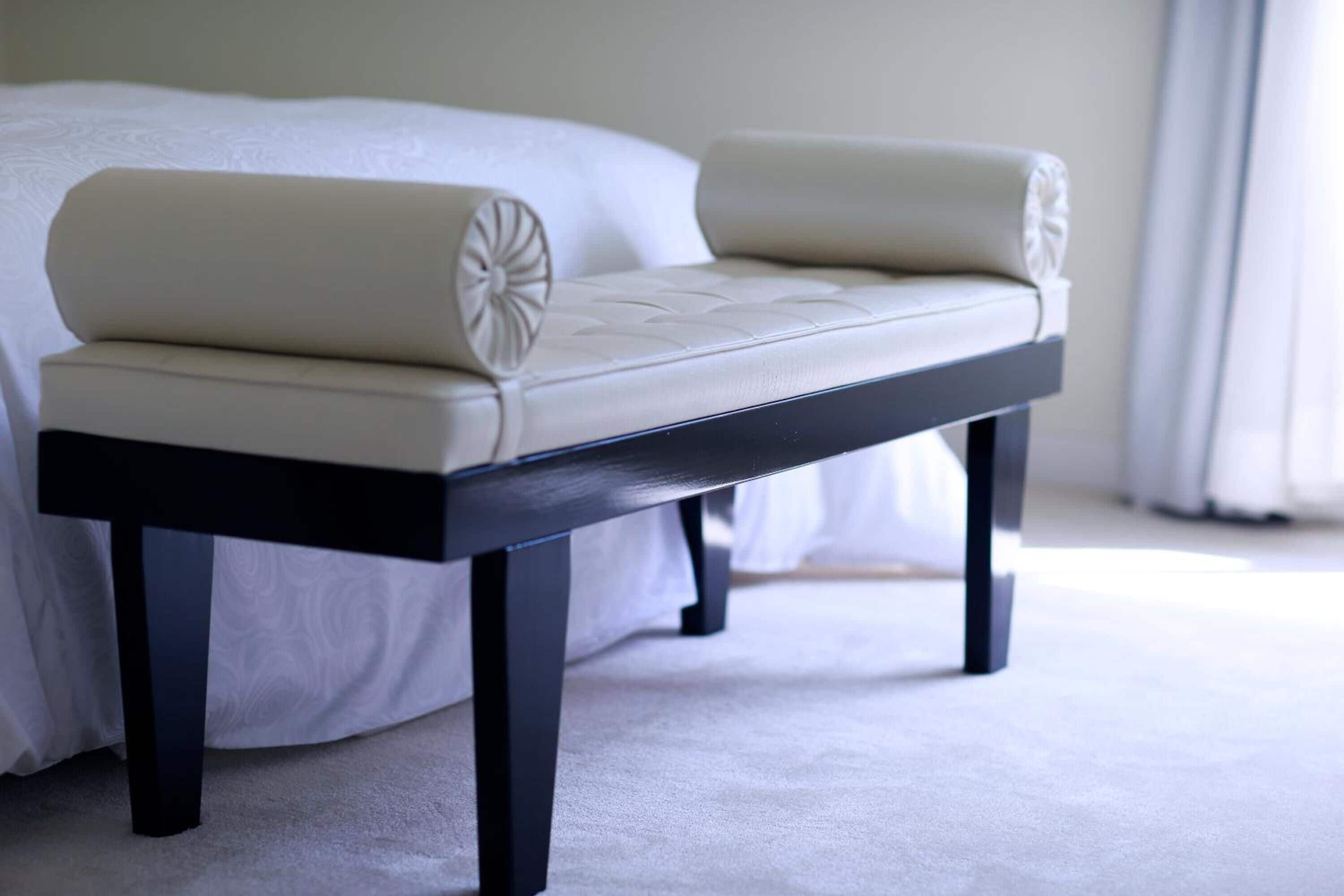 A bed with a white headboard and a black nightstand beside it.