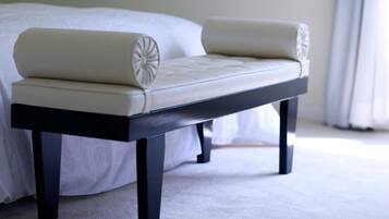 A bed with a white headboard and a black nightstand beside it.