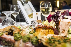 A dining table with various dishes, glasses of wine, and a menu card. - Villaggio Camping Calypso (Caulonia)