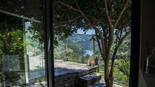 A stone deck with a view of a lake and hills. - Cabo Do Mundo Casa Rural (Chantada)