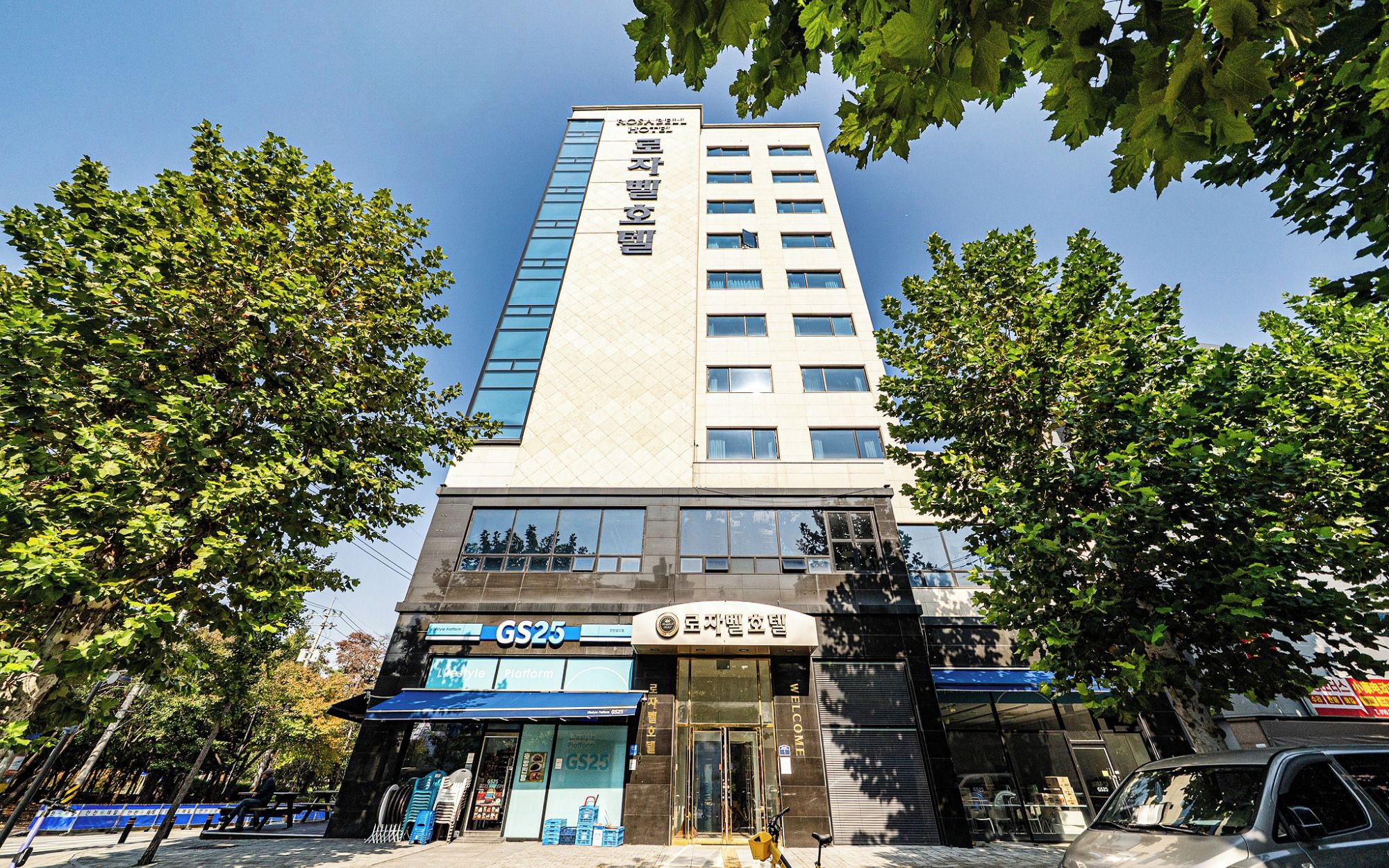 A hotel with a modern facade, a visible entrance, and a sign indicating a platform named GS25.