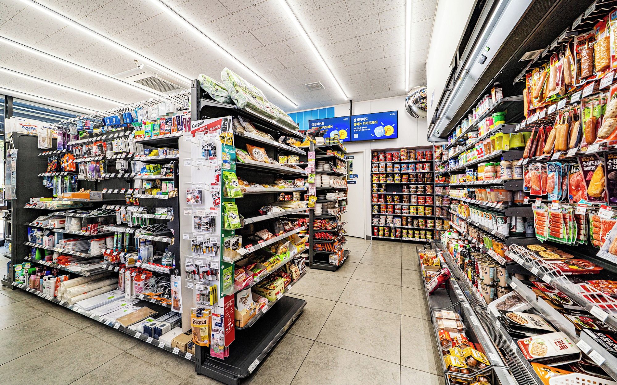 Un pasillo de supermercado con diversos productos envasados, como aperitivos y artículos para el hogar.