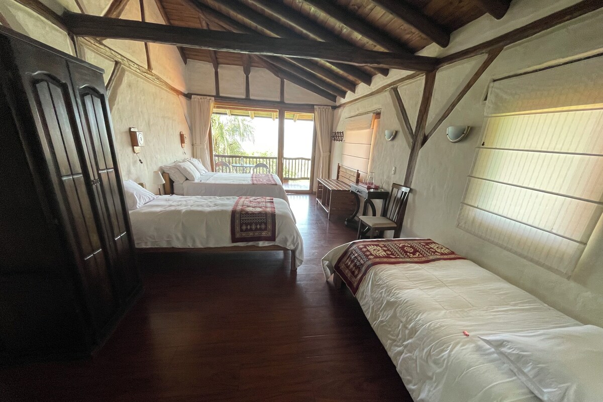 Une chambre avec deux lits, un plafond en bois et une fenêtre donnant sur un beau paysage.