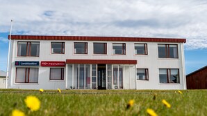 A two-story building with a sign for Landsbankinn and Posturinn. - The View Apartments (Fjardabyggd)
