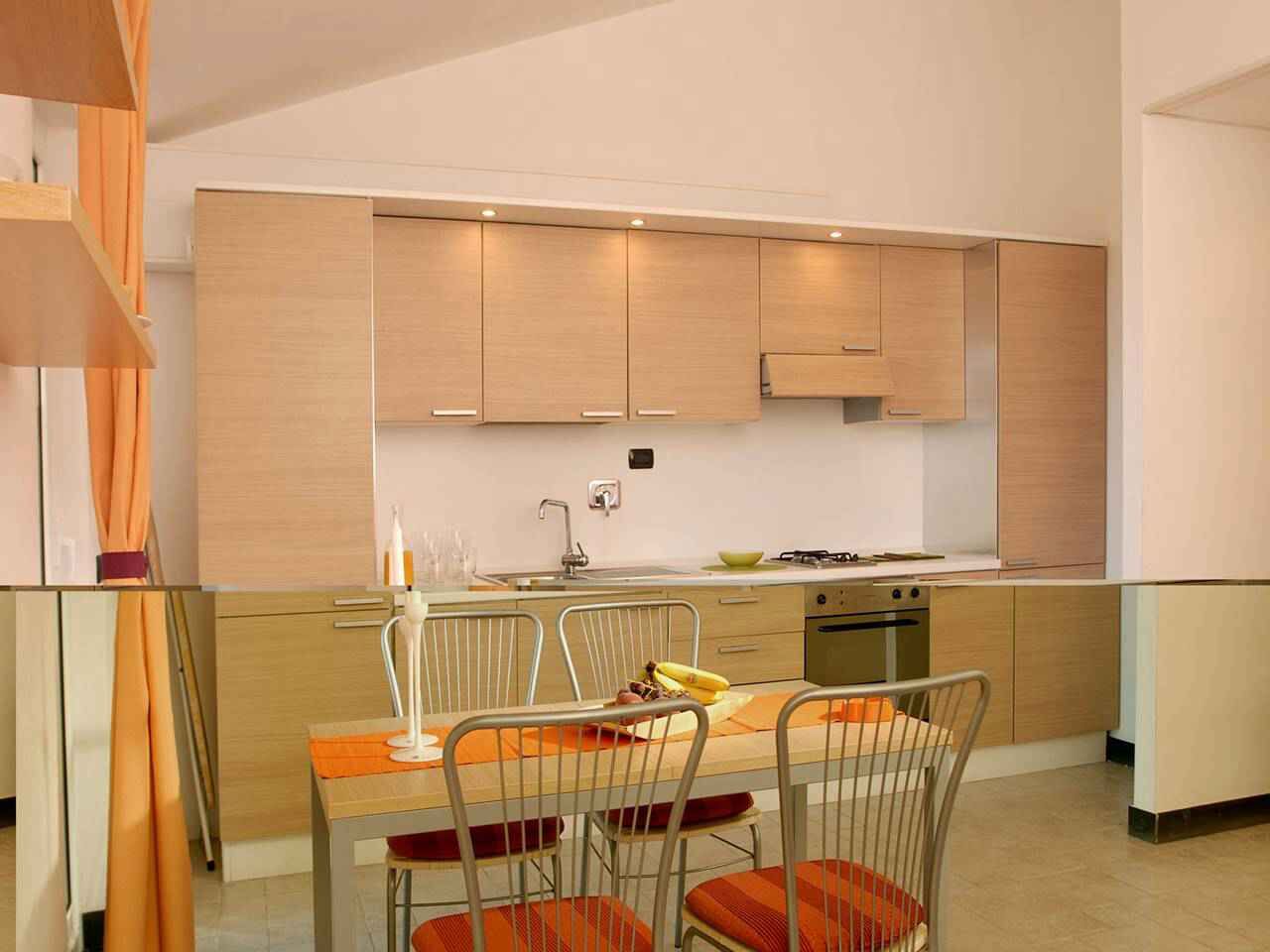 Eine moderne Küche mit Holzausstattung, einem Esstisch mit Stühlen und einem eingebauten Backofen.