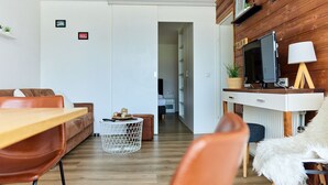 A modern living room with a wooden TV stand, a dining table, and a sofa. - 1209 Bart´s Apartment 9 (Gaschurn)