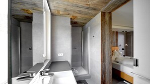 A modern bathroom with a large bathtub, a shower, and a toilet.