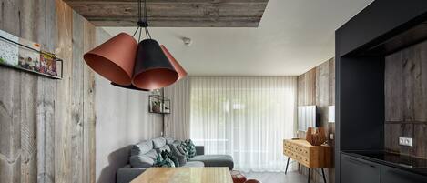 A modern kitchen with a wooden ceiling, a dining area with a long table, and a built-in oven.