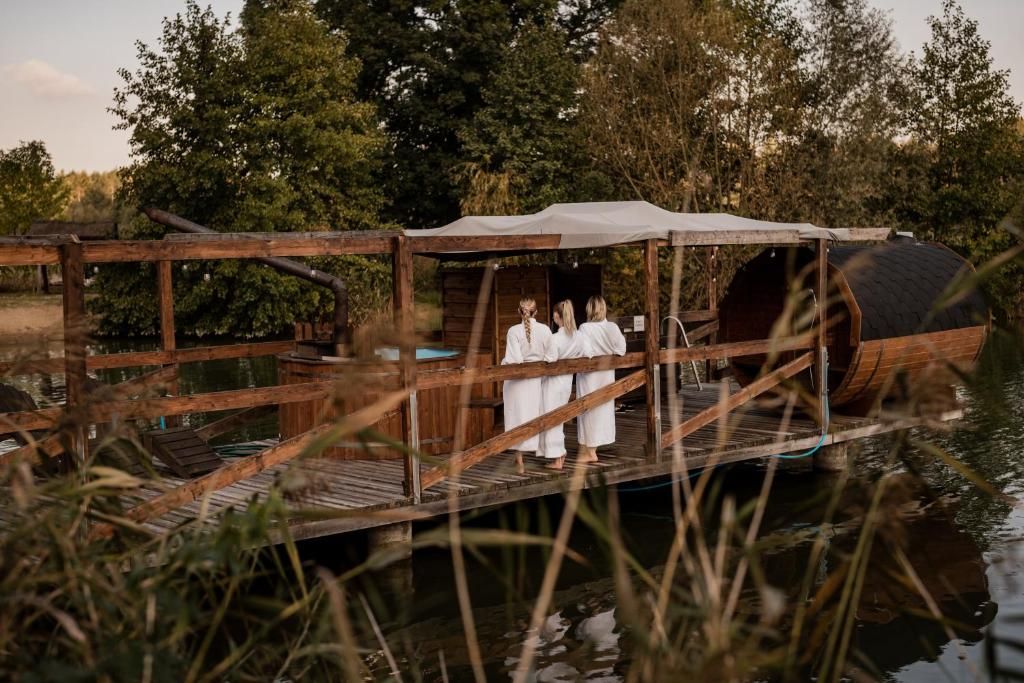 A wooden dock with a covered walkway leading to a rustic building.