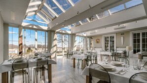 A spacious dining area with high ceilings and large windows, allowing natural light to fill the space. - Hotel Przy Dworze (Lesna Podlaska)