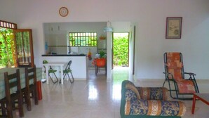 A spacious living area with a sofa, dining table, chairs, and a kitchen in the background. - Finca Vacacional Villavicencio (Villavicencio)