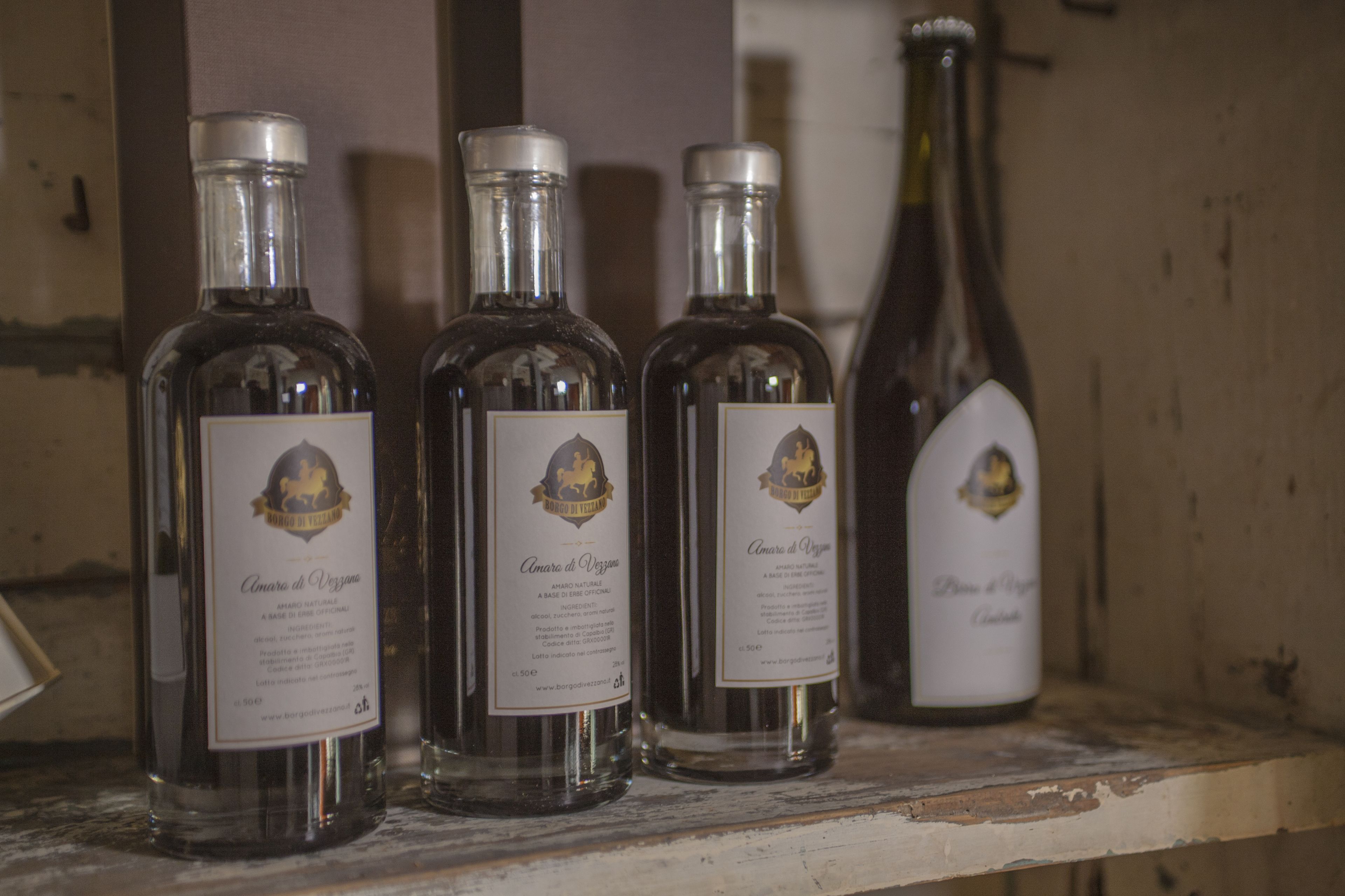 Three bottles of Amaro di Veggia on a shelf.