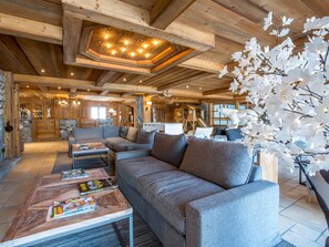 Cozy space with a rustic ceiling, stone fireplace, and comfortable seating area.