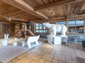 Cozy retreat with a large polar bear sculpture, wooden playhouse, and stone wall.