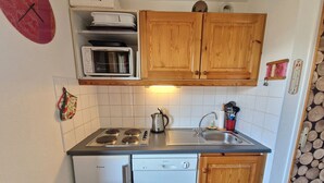 A compact kitchen with a stove, microwave, and dishwasher. - 3-room apartment for 4/6 people in Valfréjus with balcony (Valfréjus)