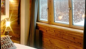 Una habitación acogedora con paredes de madera y un ventanal grande.