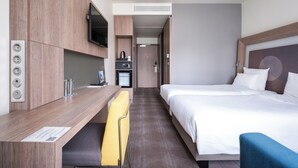 A hotel room with a bed, a desk, a TV, and a small kitchenette. - Novotel Almaty City Center (Almaty)