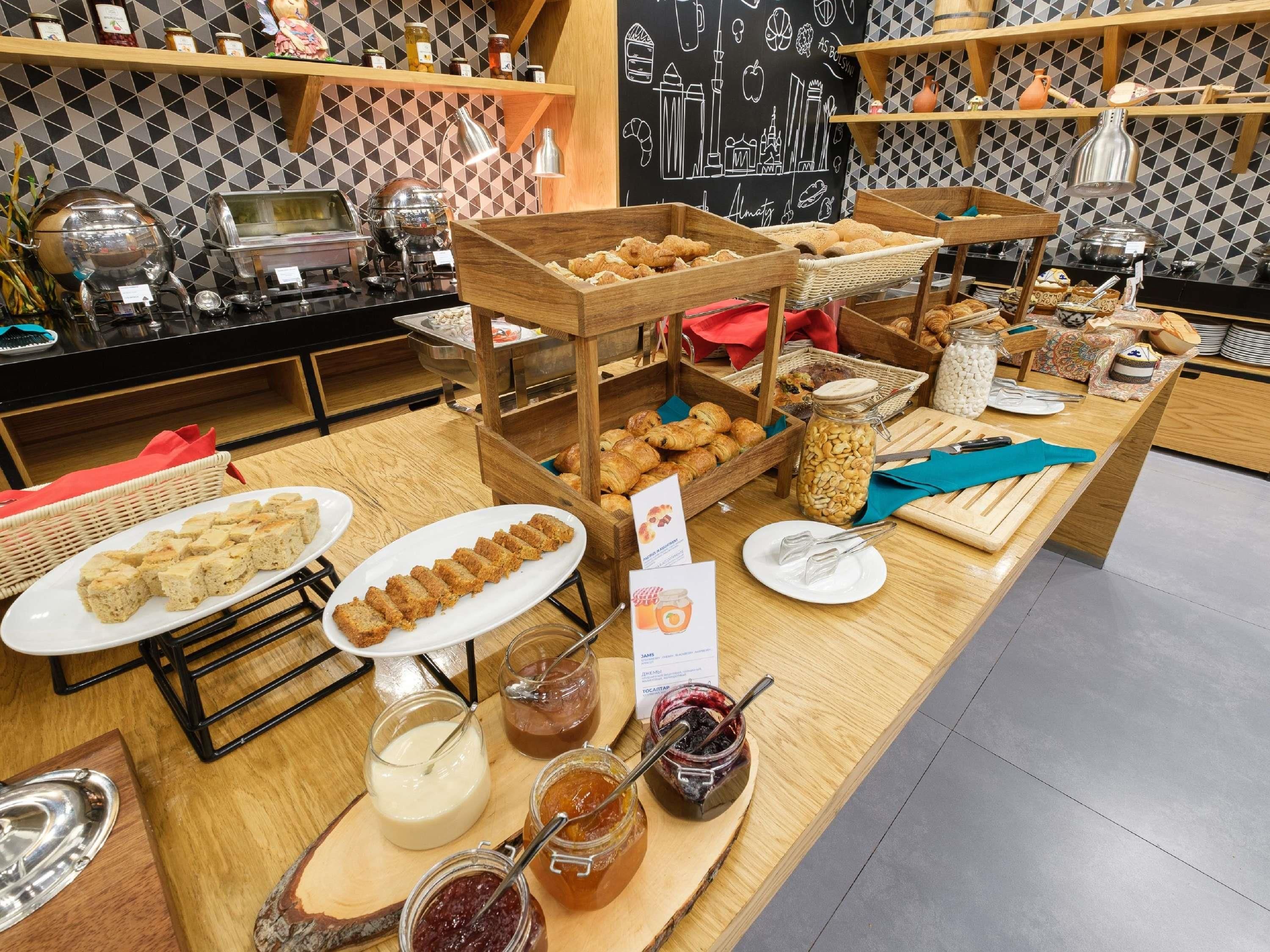 A buffet with various food items, including pastries, bread, and jars of spreads.