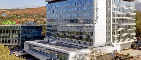 A modern hotel with a glass facade, a flat roof, and a sign reading 'NOVOTEL.'