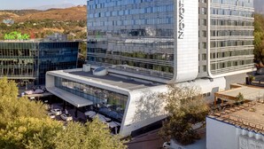 A modern hotel with a glass facade, a flat roof, and a sign reading 'NOVOTEL.' - Novotel Almaty City Center (Almaty)