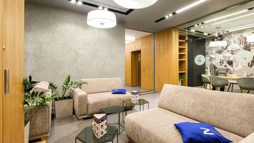 A modern interior with sofas, a coffee table, and a dining area.