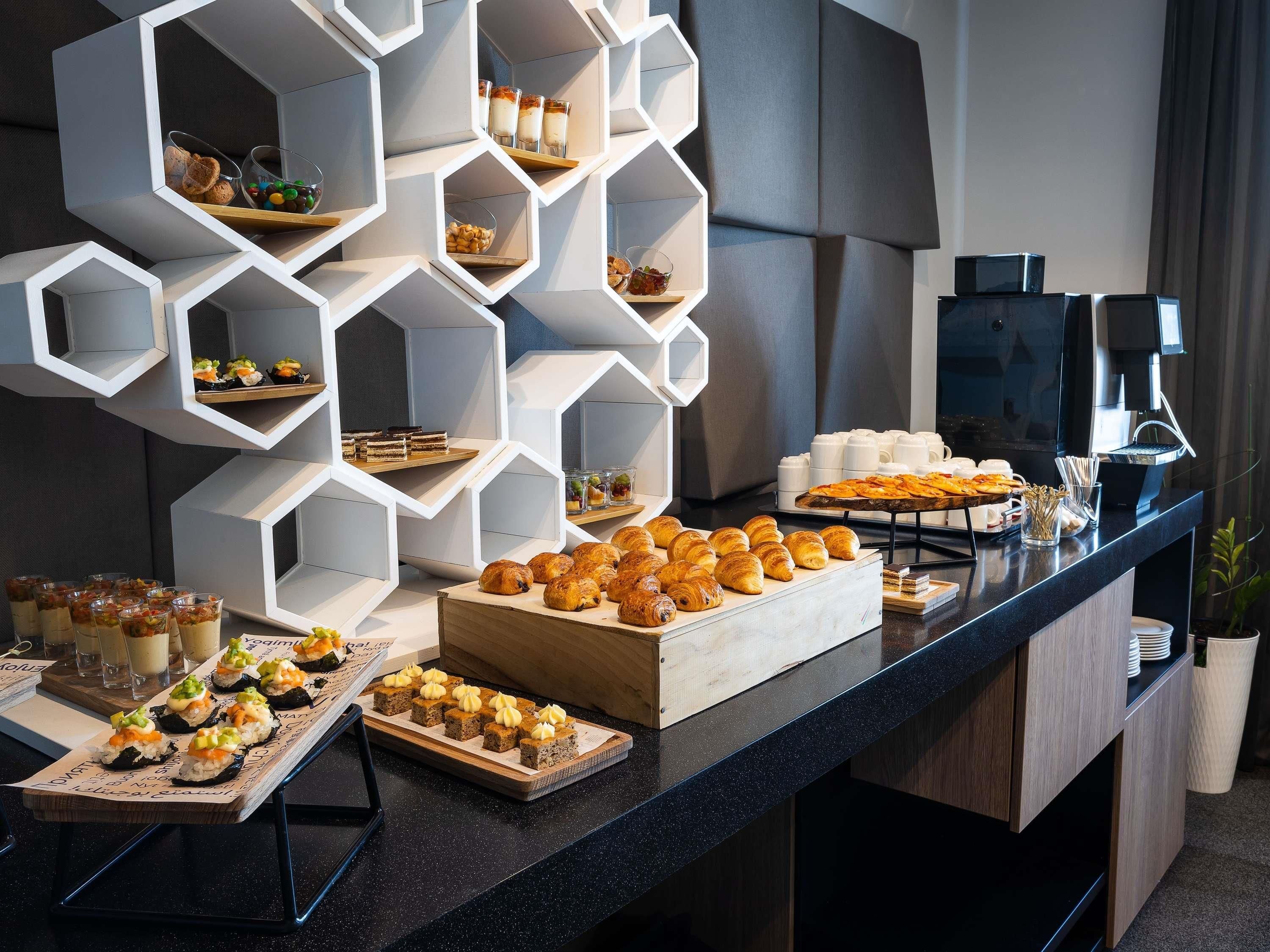 A buffet with various food items and a coffee machine.