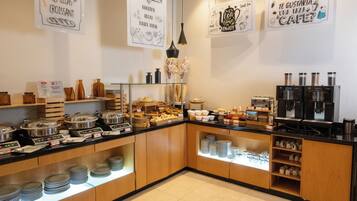 Un bufé de desayuno con diversas opciones de comida y máquinas de café.