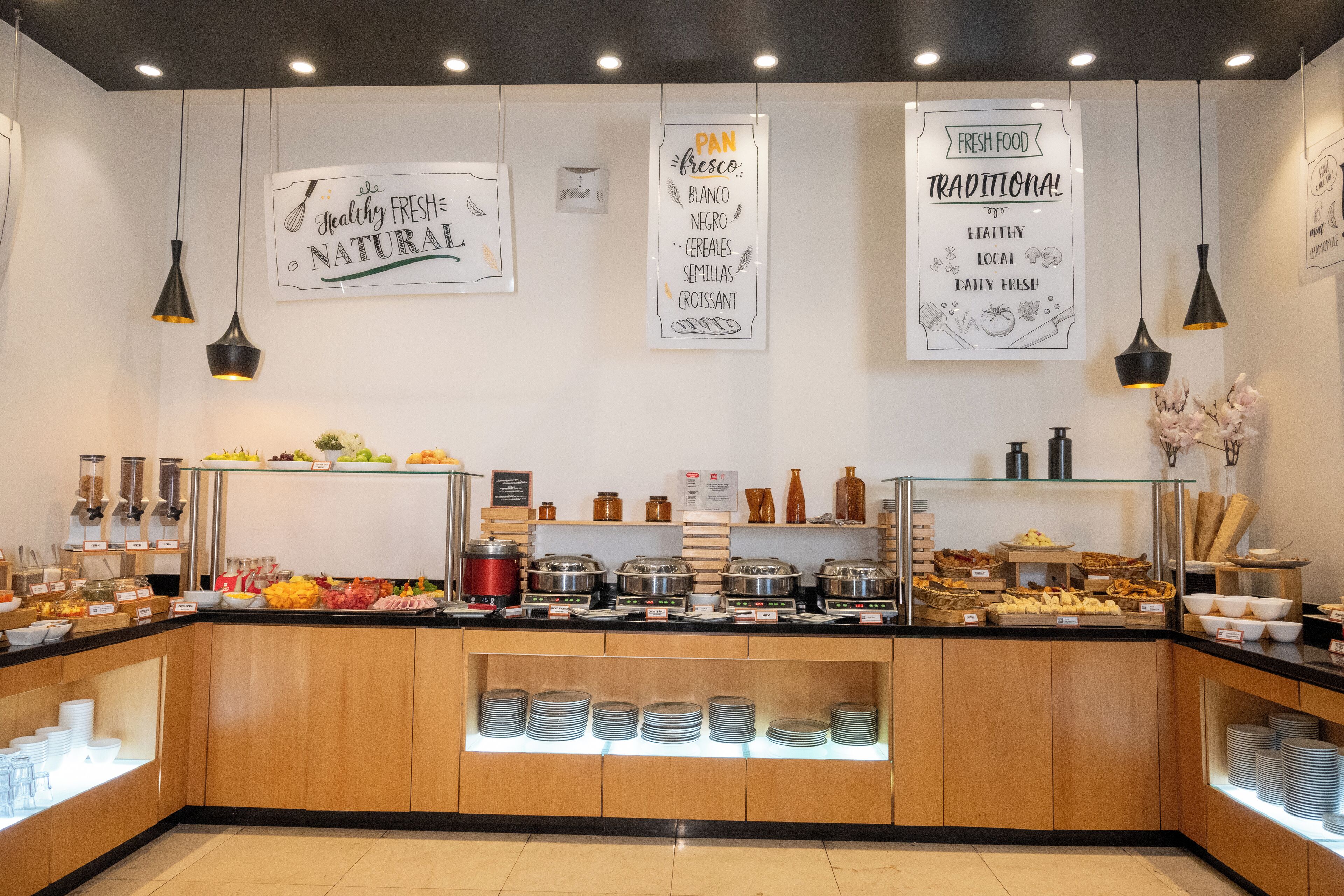 Un área de bufé con diversas opciones de comida y utensilios.